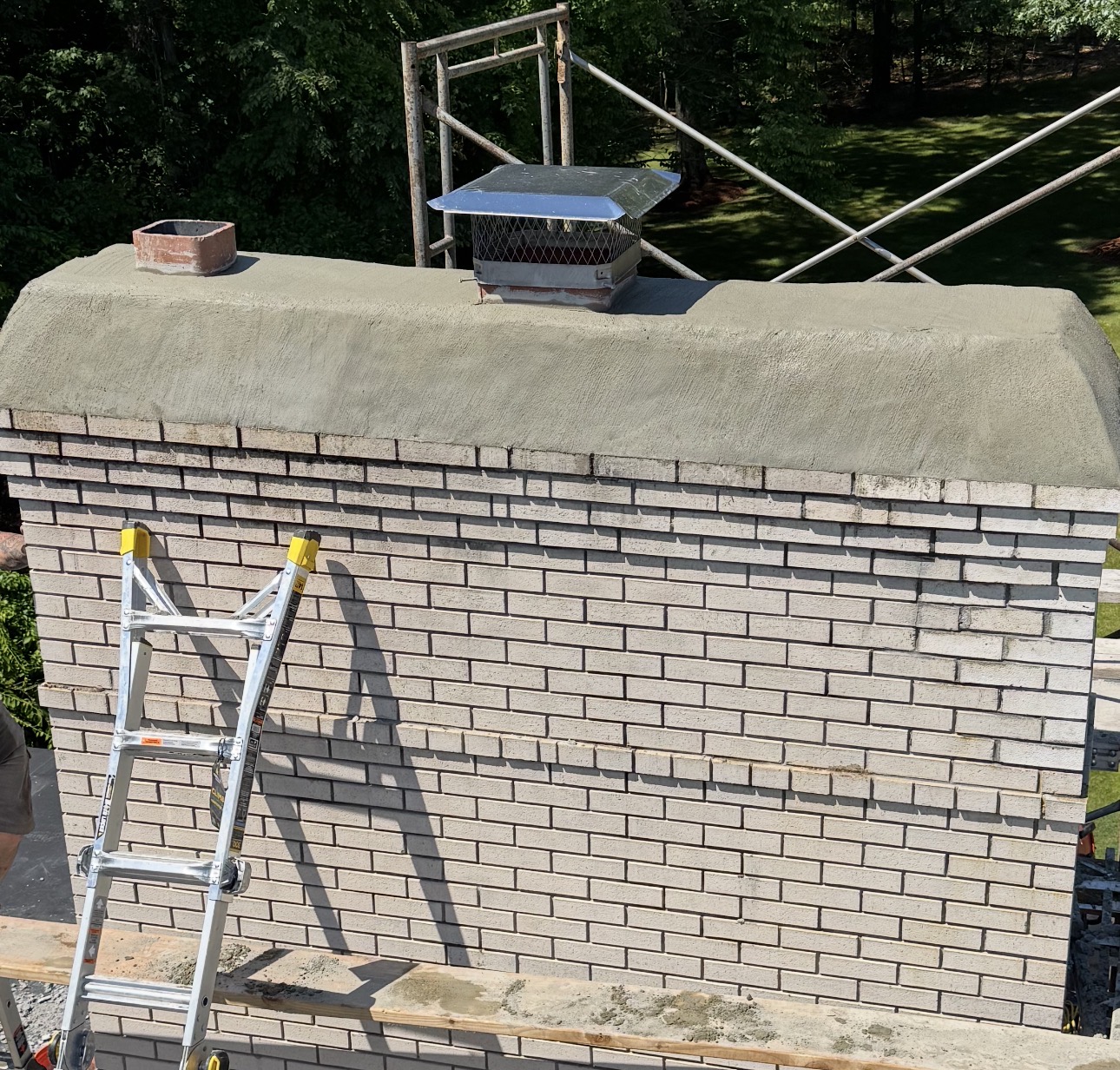 Brick chimney after restoration with a newly formed protective crown